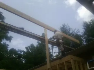 Carpenter setting a ridge beam over a new addition frame — Ice Dam Removal by Roofing Brothers in Mc Coy