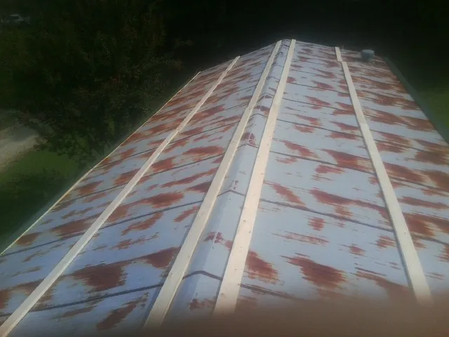 Rusted metal roof panels with new wood purlins before replacement — Storm Damage Roof Repair in Mc Coy by Roofing Brothers