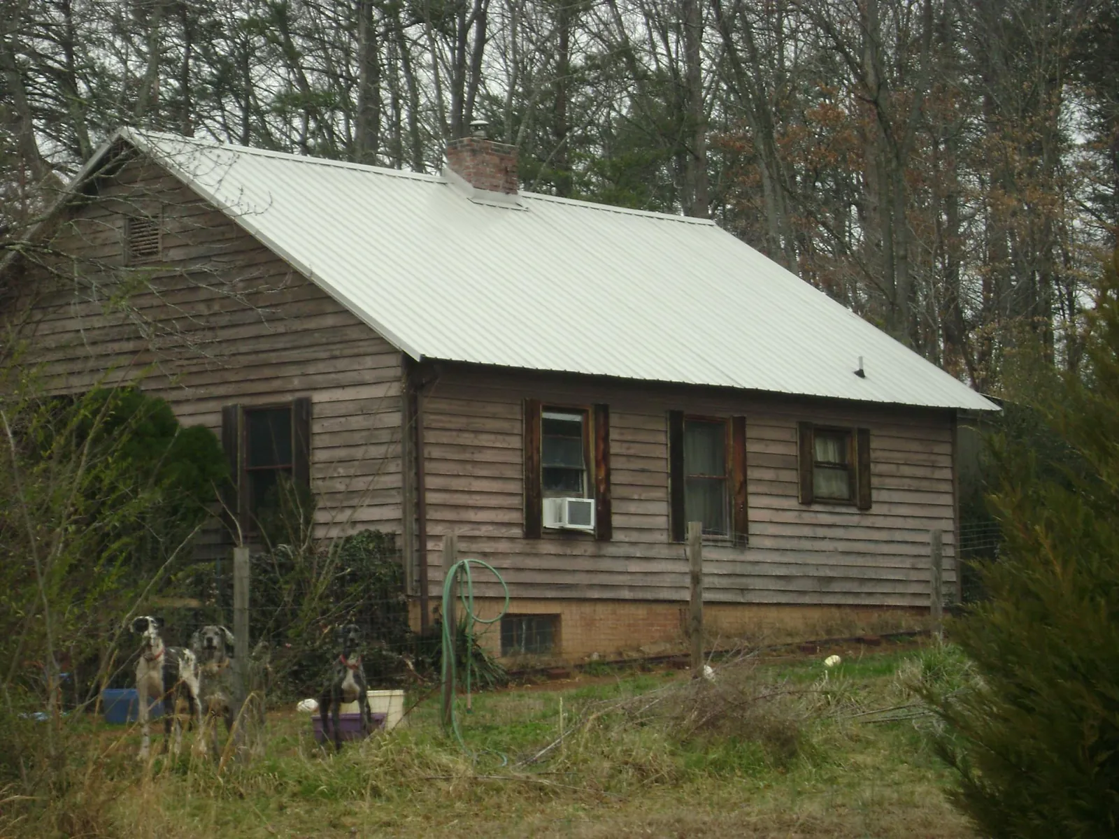 White metal roof on an old wood sided farmhouse, from a Metal Roof Installation job in Mc Coy